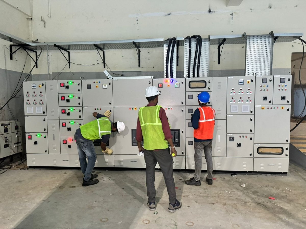 Royal Infra Projects crew in safety gear commissioning an LT distribution panel board